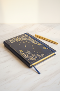Navy cherry blossom gilded A4 journal cover on marble desk