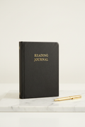 Black faux leather Reading Journal on marble desk